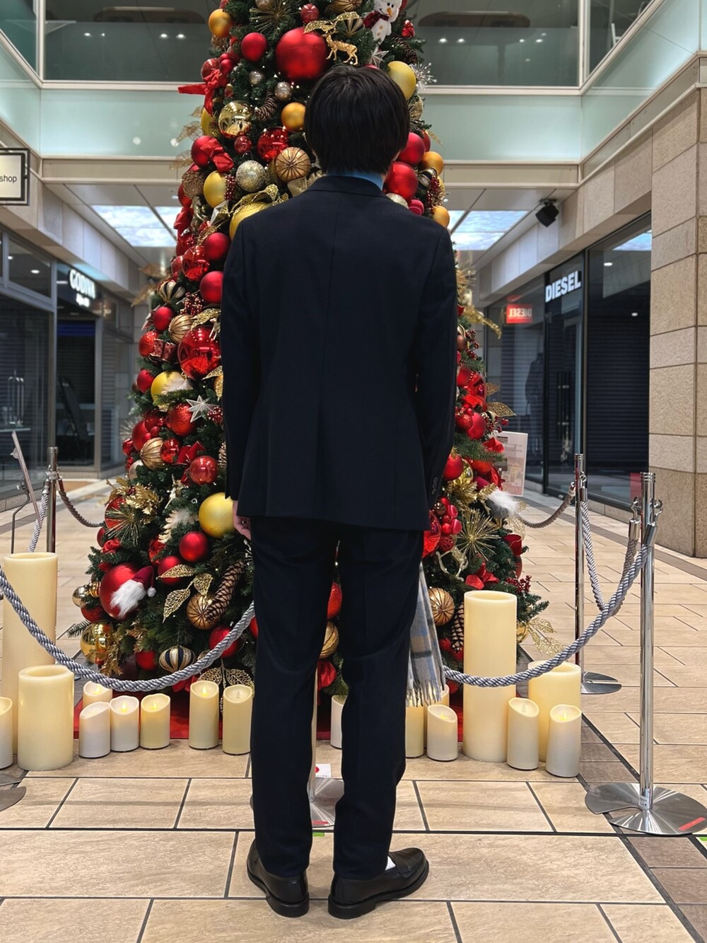 ブルー系のテーラードジャケット、ブルー系のニット/セーター、ブルー系のスラックスを着用したメンズの冬コーディネートの3枚目の写真