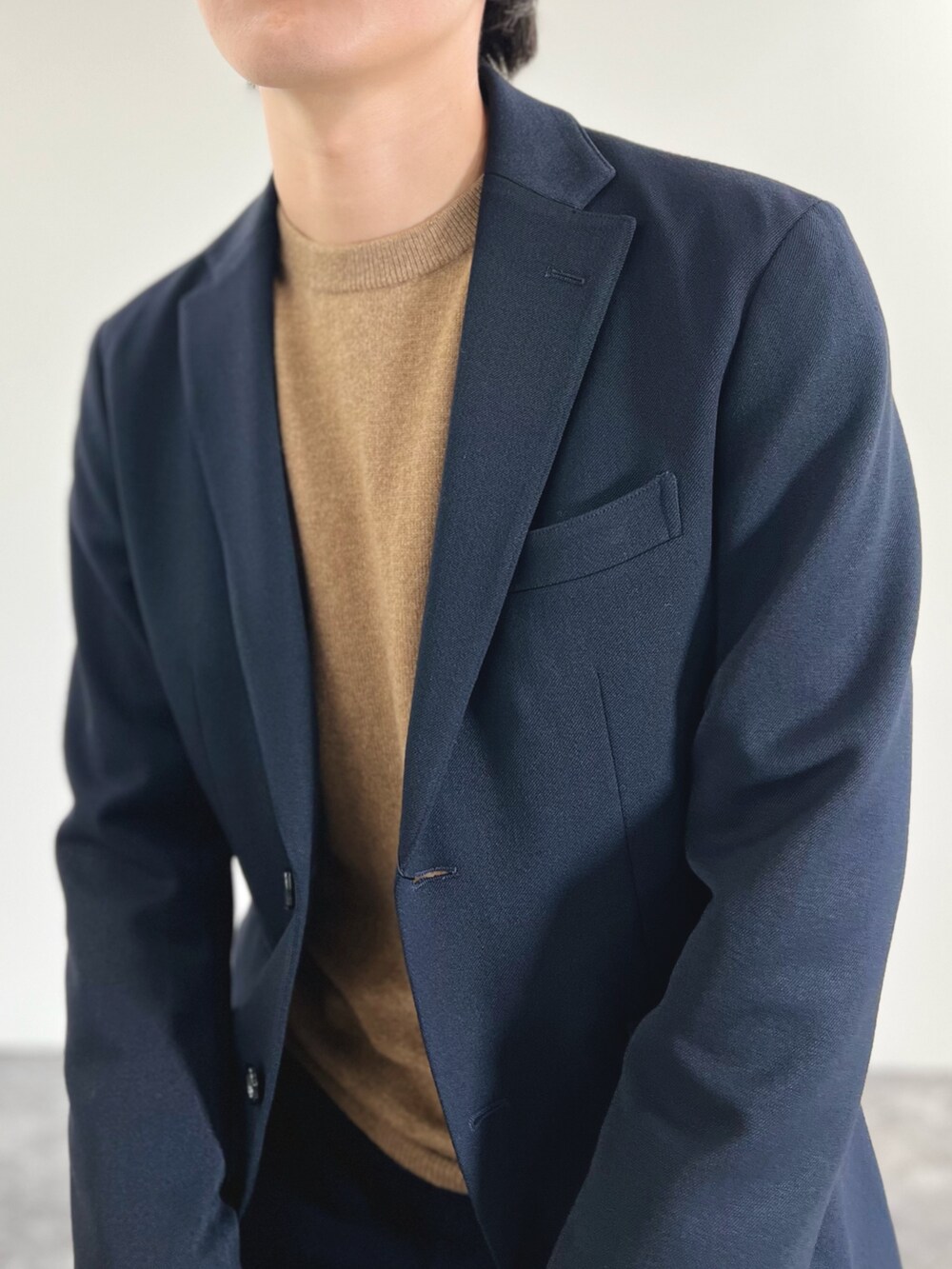 ブルー系のその他パンツ、ベージュ系のニット/セーター、ブルー系のテーラードジャケットを着用したメンズの秋コーディネートの6枚目の写真