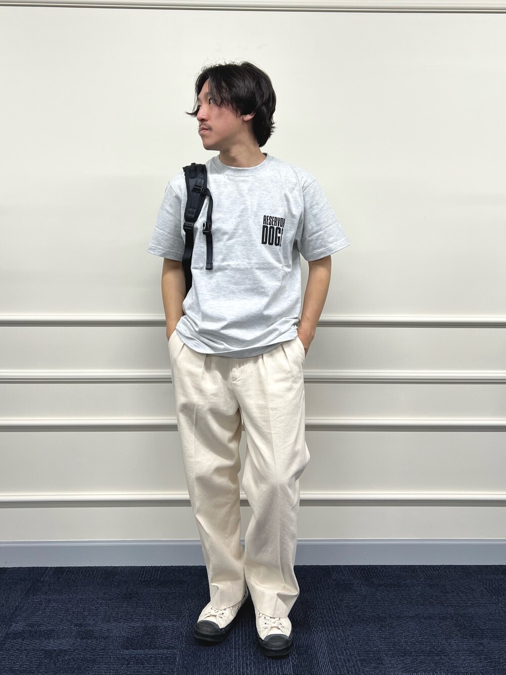 グレー系のTシャツ/カットソー、ブラック系のバックパック/リュック、ホワイト系のデニムパンツを着用したメンズの冬コーディネートの2枚目の写真