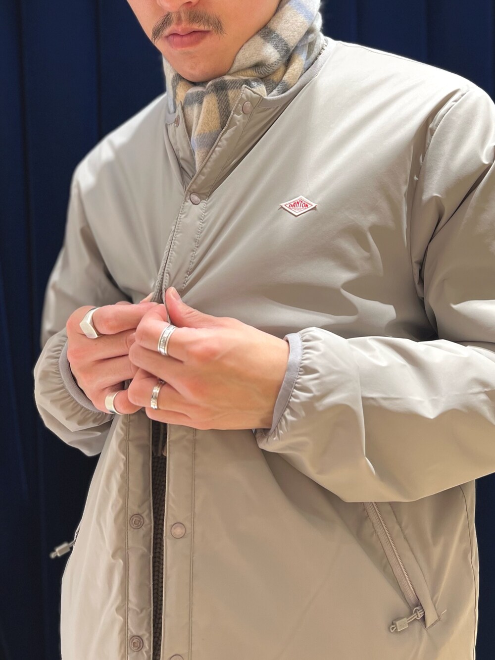 グレー系のブルゾン、ブラック系のシューズ、グレー系のマフラーを着用したメンズの冬コーディネートの7枚目の写真