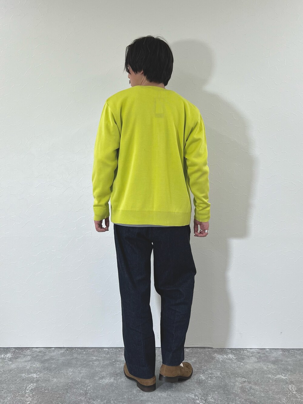 イエロー系のカーディガン/ボレロ、ホワイト系のTシャツ/カットソー、ブルー系のデニムパンツを着用したメンズの冬コーディネートの7枚目の写真
