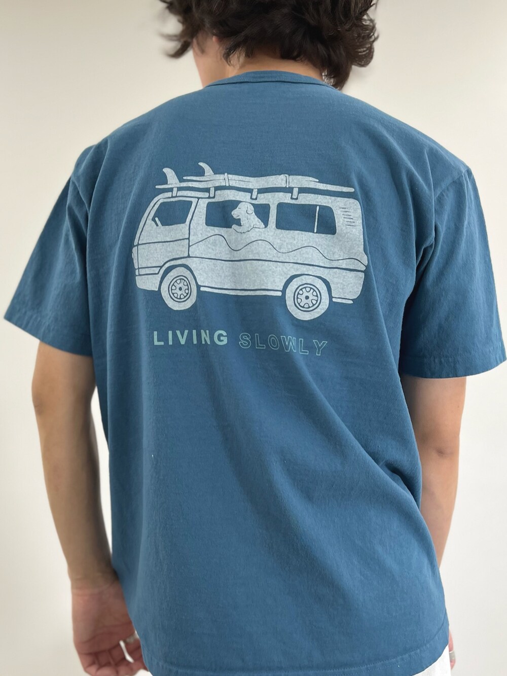 ブルー系のTシャツ/カットソー、ブラック系のショルダーバッグ、ホワイト系のデニムパンツを着用したメンズの春コーディネートの7枚目の写真