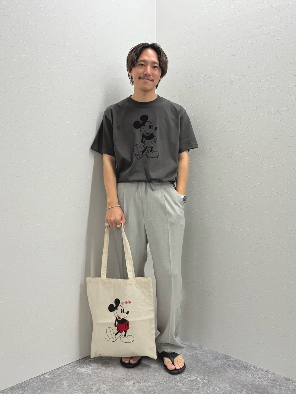 ブラック系のTシャツ/カットソー、ホワイト系のトートバッグ、ブラック系のサンダルを着用したメンズの夏コーディネートの3枚目の写真