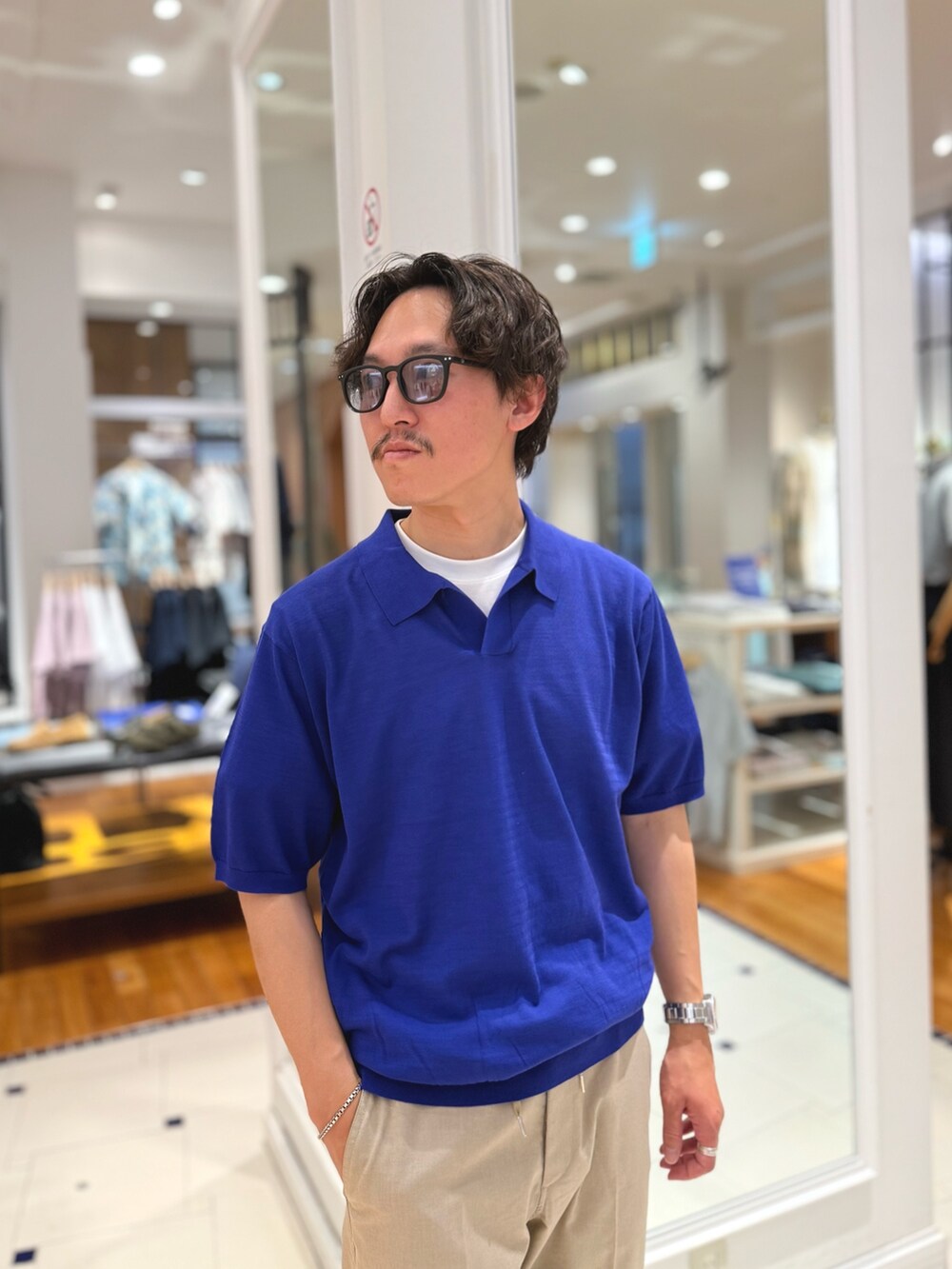 ブルー系のポロシャツ、ベージュ系のその他パンツ、ブラウン系のローファーを着用したメンズの春コーディネートの3枚目の写真