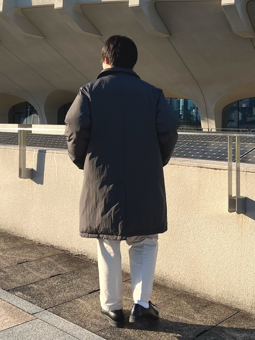 グレー系のダウンジャケット/コート、ブルー系のニット/セーター、ブラック系のその他シューズを着用したメンズの秋コーディネートの7枚目の写真