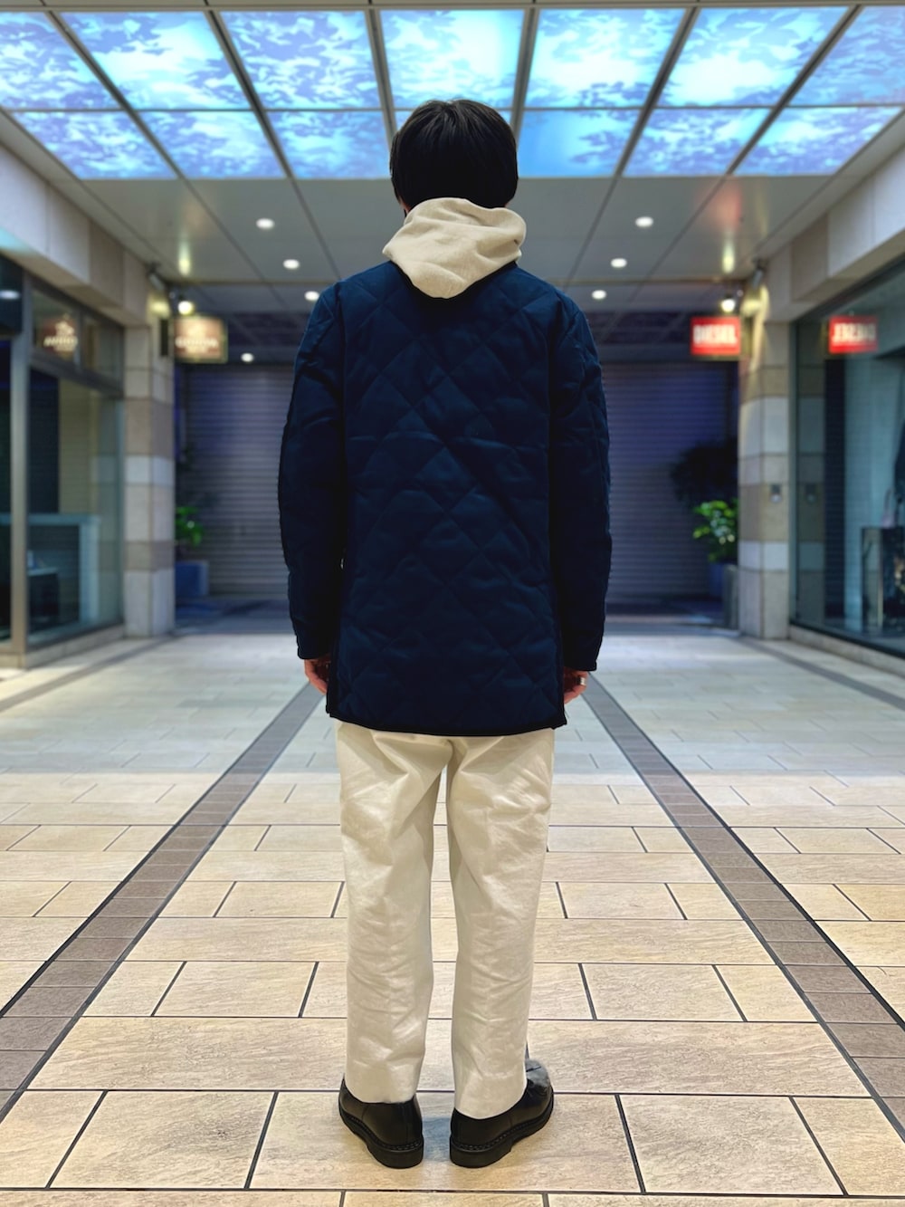 ホワイト系のパーカー、ブルー系のダウンジャケット/コート、ブラック系のシューズを着用したメンズの冬コーディネートの4枚目の写真