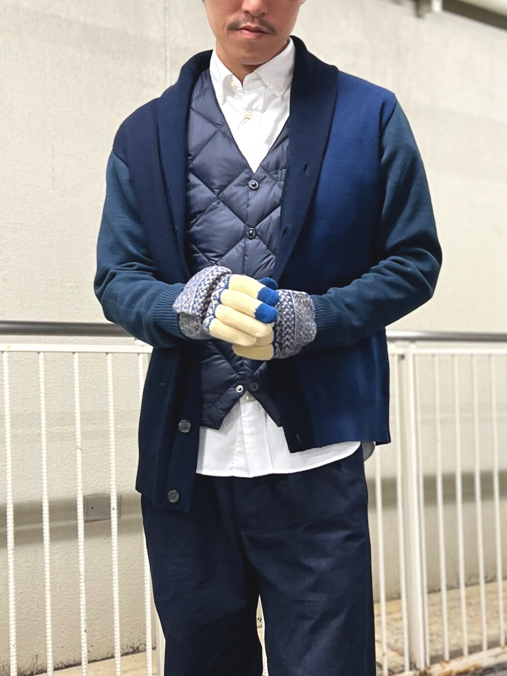 ブルー系のカーディガン/ボレロ、ブルー系のダウンベスト、ホワイト系のシャツ/ブラウスを着用したメンズの秋コーディネートの4枚目の写真