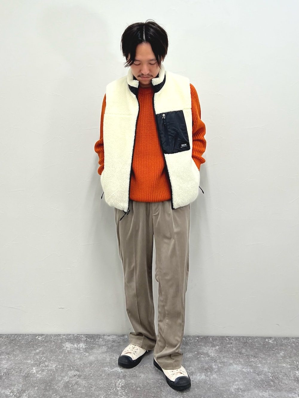 ホワイト系のダウンベスト、ベージュ系のその他パンツを着用したメンズの秋コーディネートの4枚目の写真