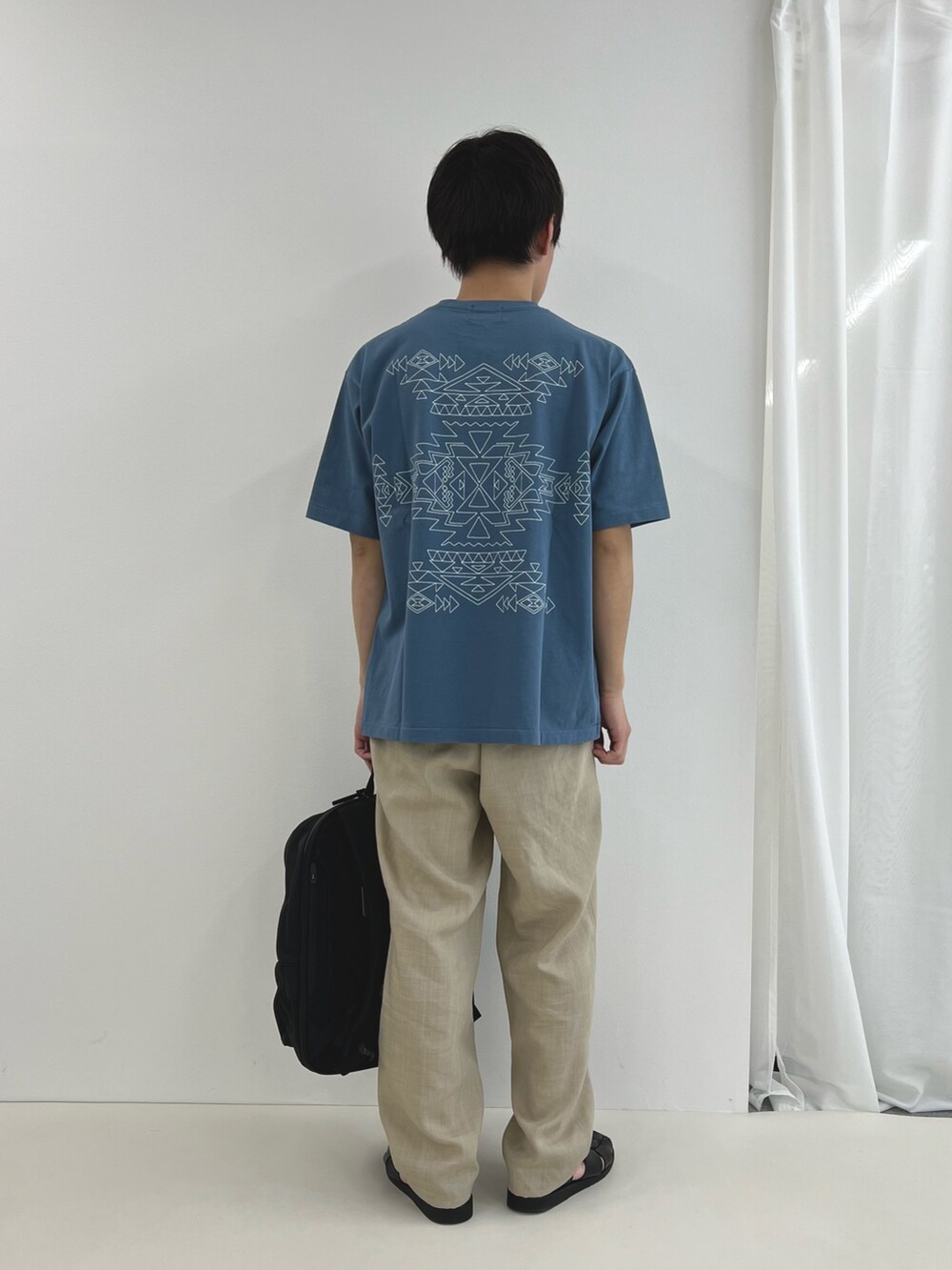 ブルー系のTシャツ/カットソー、ブラック系のバックパック/リュックを着用したメンズの春コーディネートの2枚目の写真