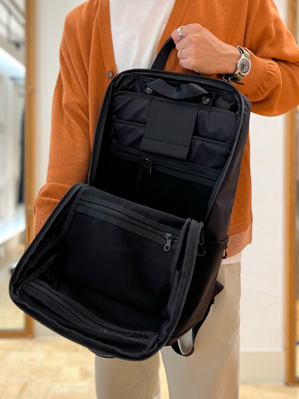 イエロー系のカーディガン/ボレロ、ブラック系のバックパック/リュックを着用したメンズの秋コーディネートの4枚目の写真