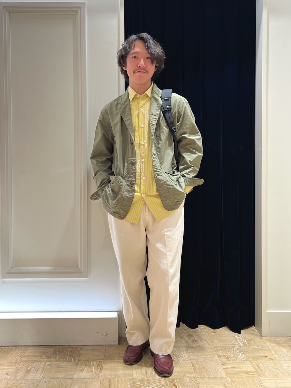 グリーン系のミリタリージャケット、レッド系のローファー、ホワイト系のデニムパンツを着用したメンズの春コーディネートの2枚目の写真