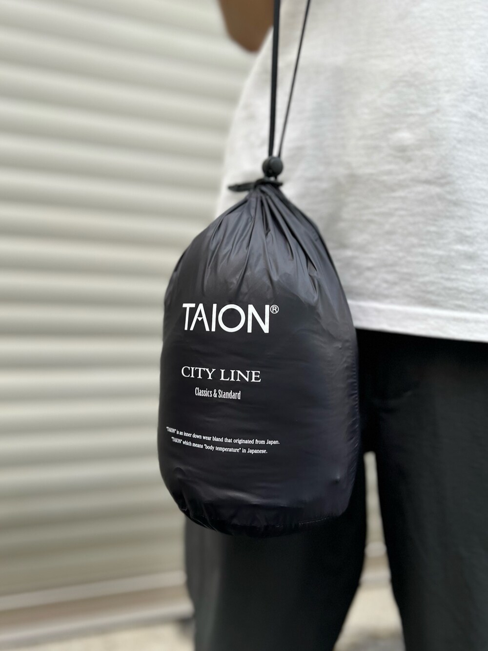 グレー系のその他パンツ、ブラック系のダウンジャケット/コートを着用したメンズの夏コーディネートの6枚目の写真