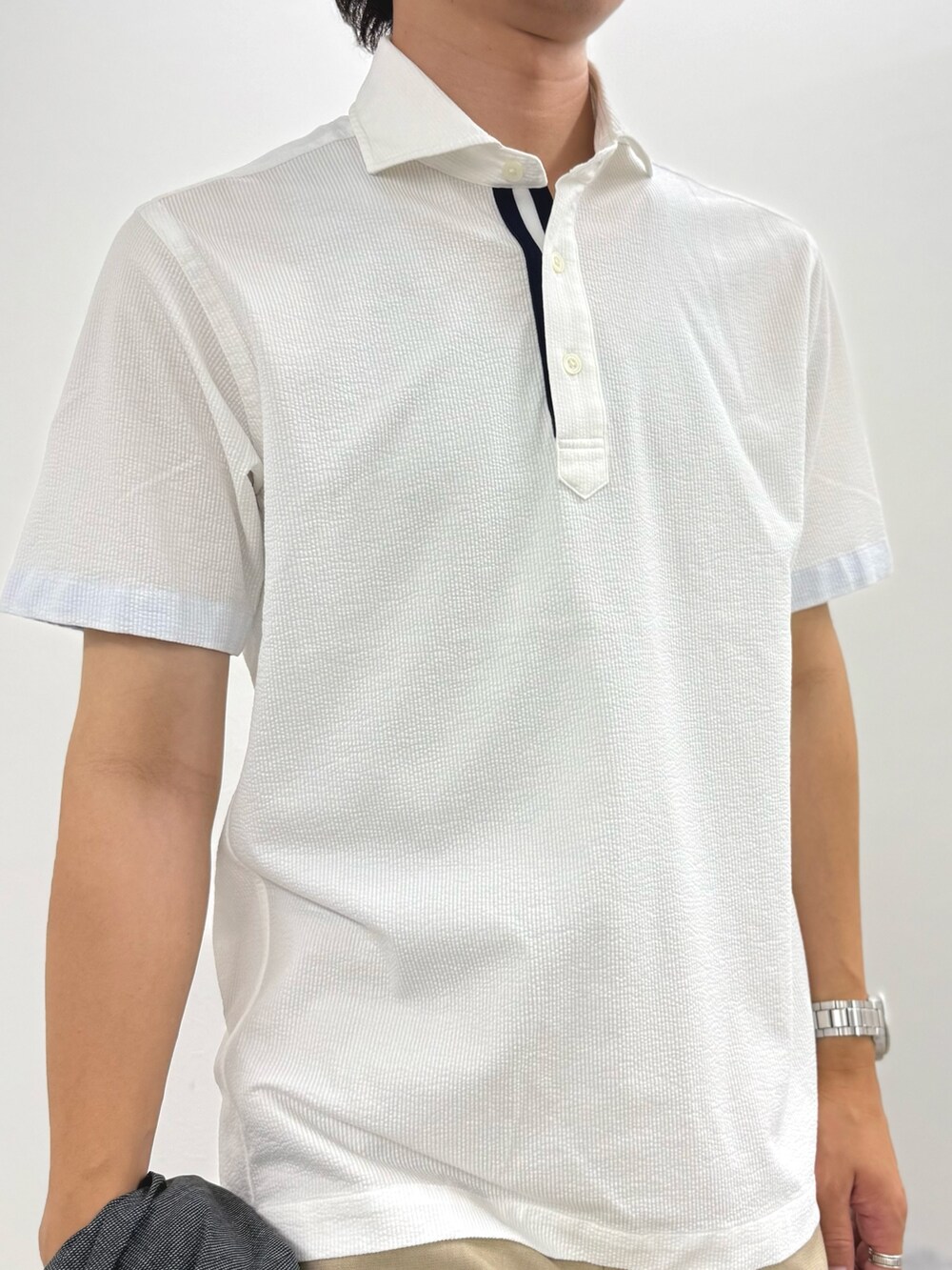 ホワイト系のポロシャツ、ベージュ系のチノパンツ、イエロー系のローファーを着用したメンズの夏コーディネートの4枚目の写真