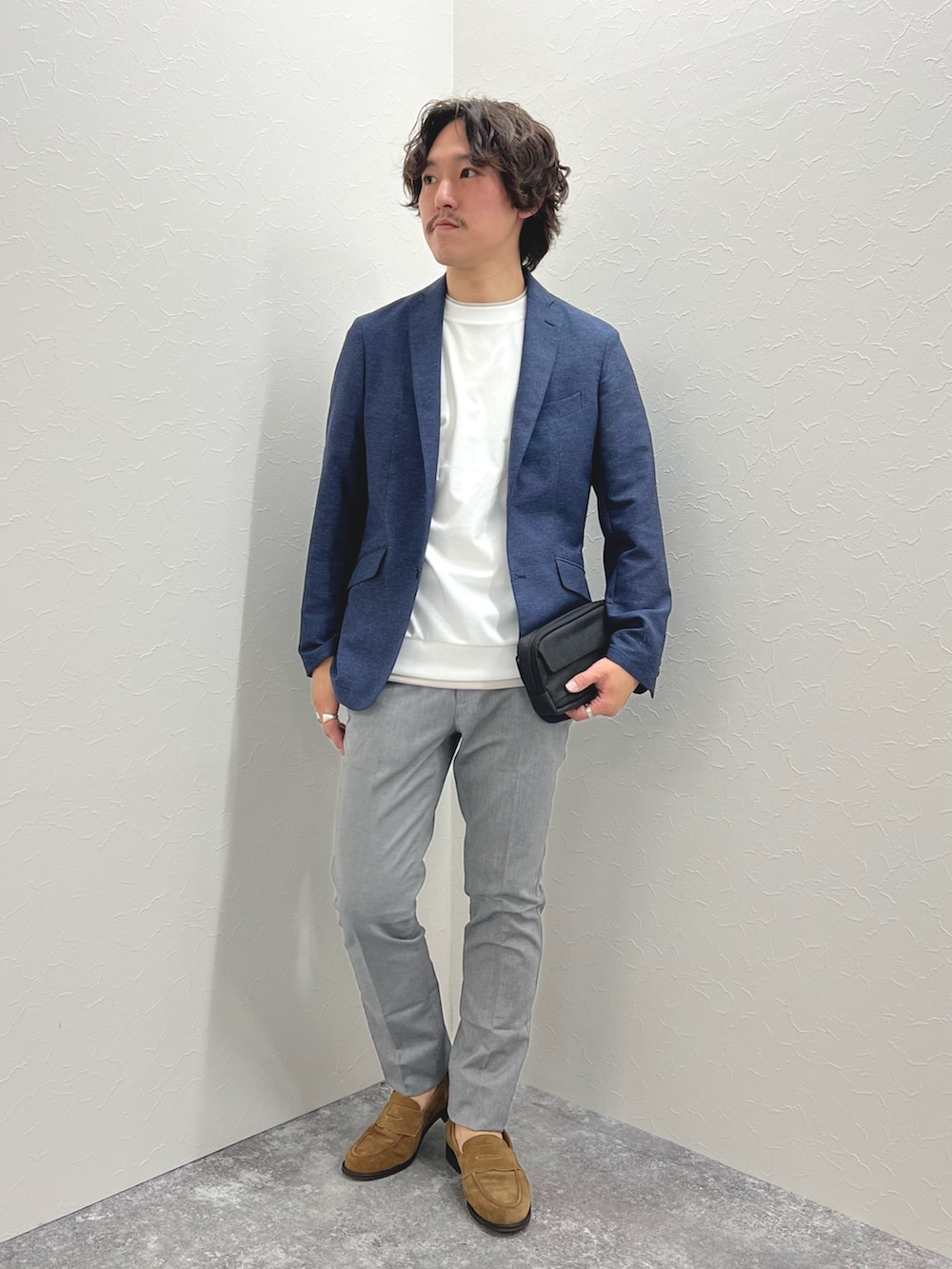 ブルー系のテーラードジャケット、ホワイト系のTシャツ/カットソー、ブラック系のショルダーバッグを着用したメンズの春コーディネートの2枚目の写真