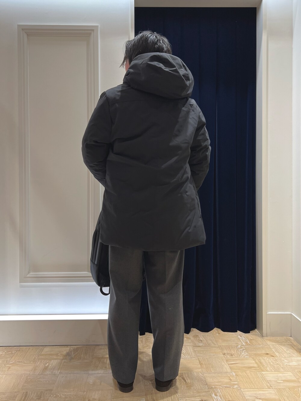 ブラック系のダウンジャケット/コート、グレー系のカーディガン/ボレロ、ブラック系のバックパック/リュックを着用したメンズの冬コーディネートの7枚目の写真