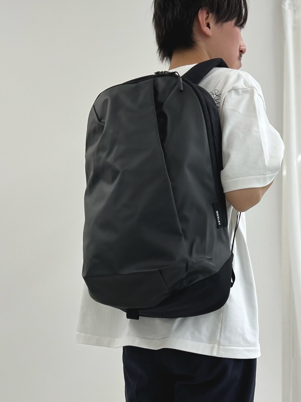 ホワイト系のTシャツ/カットソー、グレー系のバックパック/リュック、ブラック系のその他パンツを着用したメンズの春コーディネートの5枚目の写真