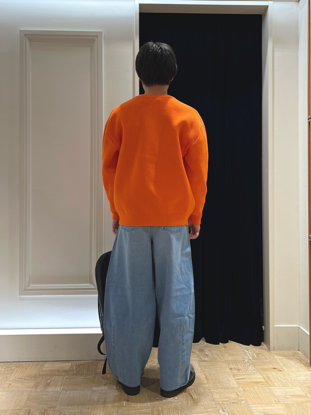 グレー系のスウェット、オレンジ系のカーディガン/ボレロ、ブラック系のシューズを着用したメンズの冬コーディネートの5枚目の写真