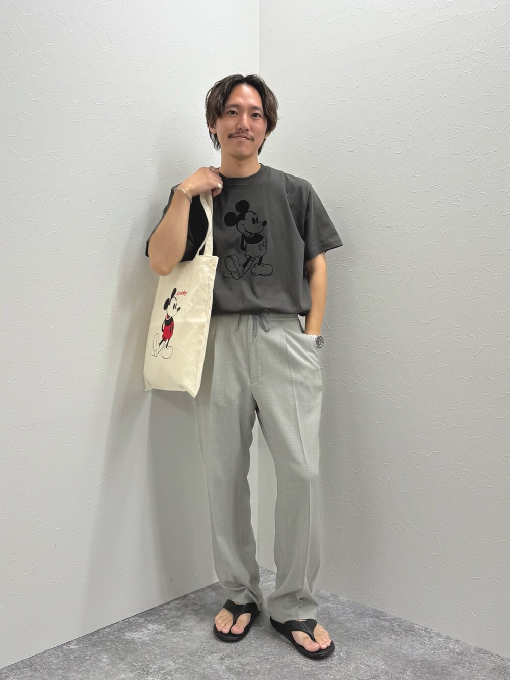 ブラック系のTシャツ/カットソー、ホワイト系のトートバッグ、ブラック系のサンダルを着用したメンズの夏コーディネートの6枚目の写真