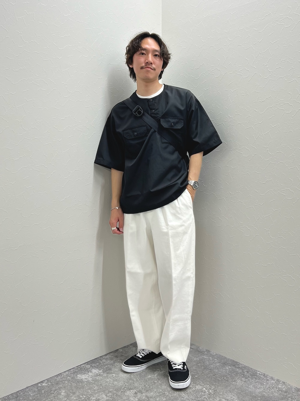 ブラック系のTシャツ/カットソー、ブルー系のショルダーバッグ、ホワイト系のデニムパンツを着用したメンズの春コーディネートの4枚目の写真