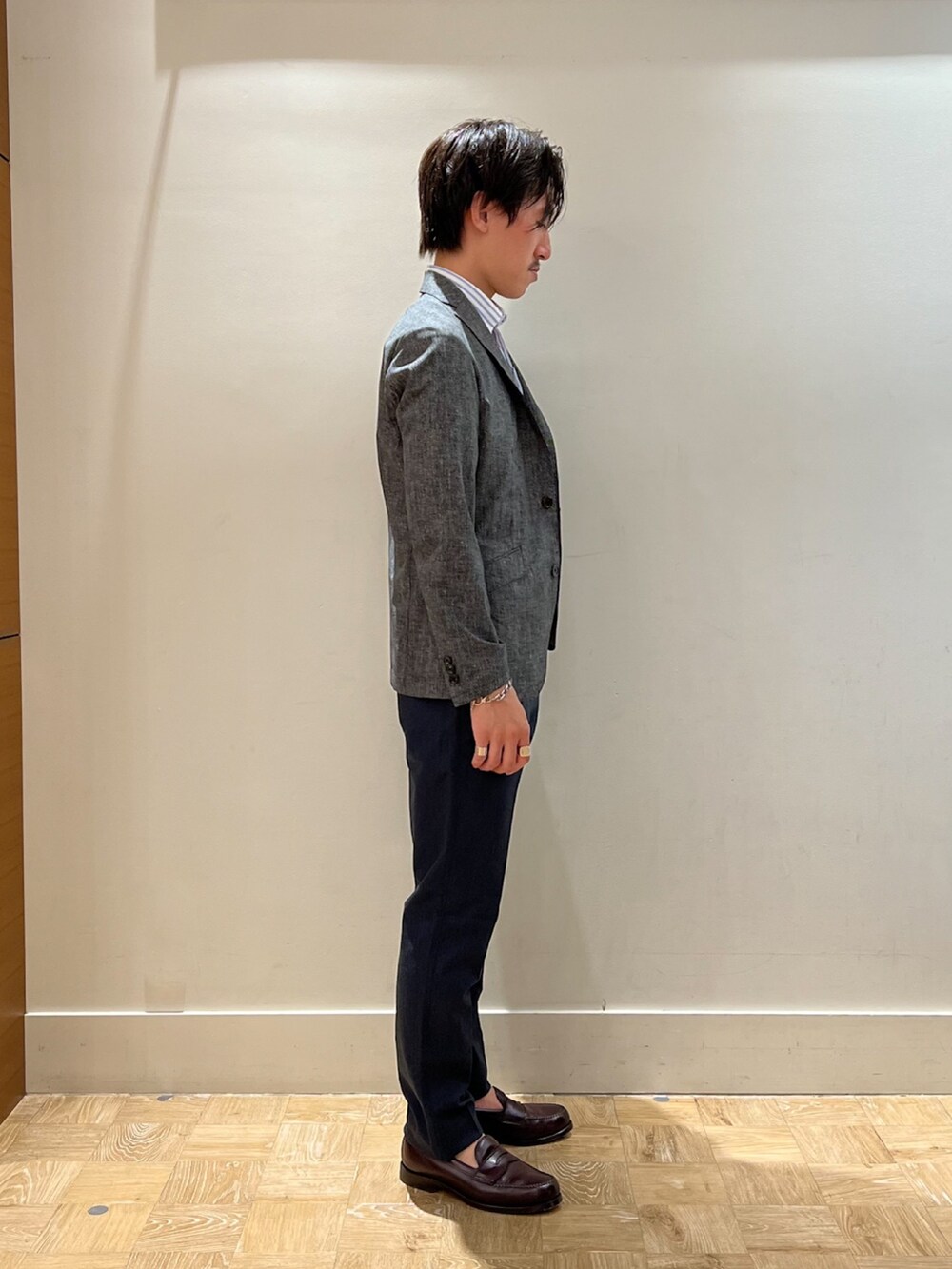 グレー系のテーラードジャケット、ホワイト系のポロシャツ、ブルー系のその他パンツを着用したメンズの夏コーディネートの3枚目の写真