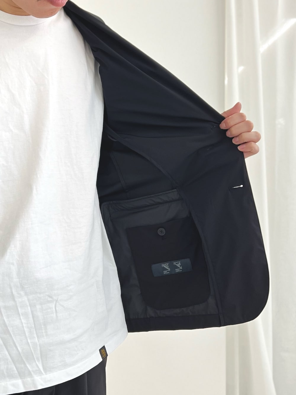 ブラック系のバックパック/リュック、ブルー系のテーラードジャケット、ブルー系のその他パンツを着用したメンズの夏コーディネートの7枚目の写真