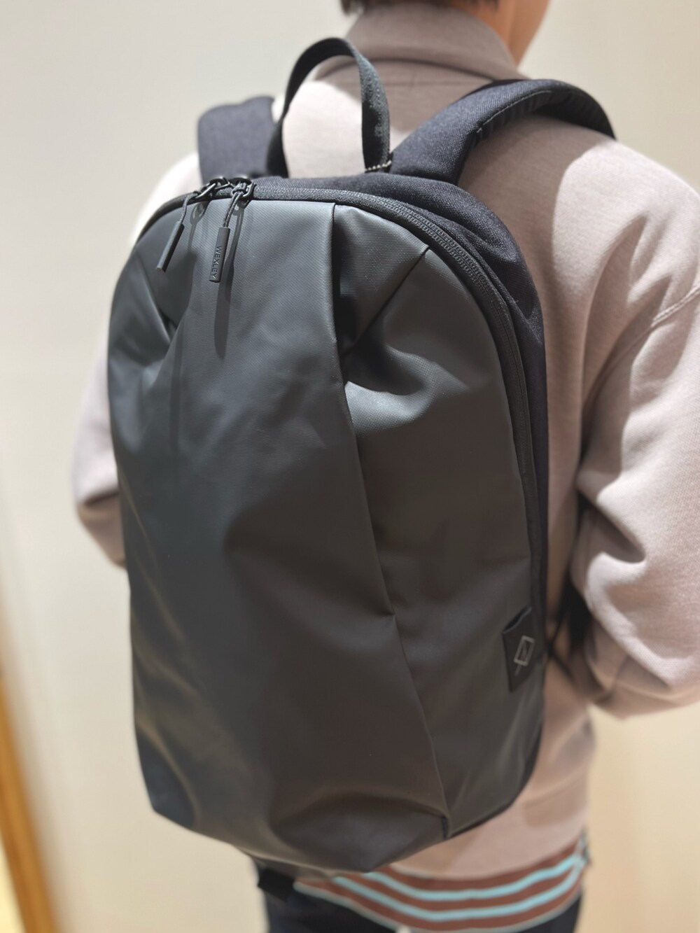 ブラウン系のローファー、ブラック系のバックパック/リュック、ブルー系のその他パンツを着用したメンズの秋コーディネートの6枚目の写真