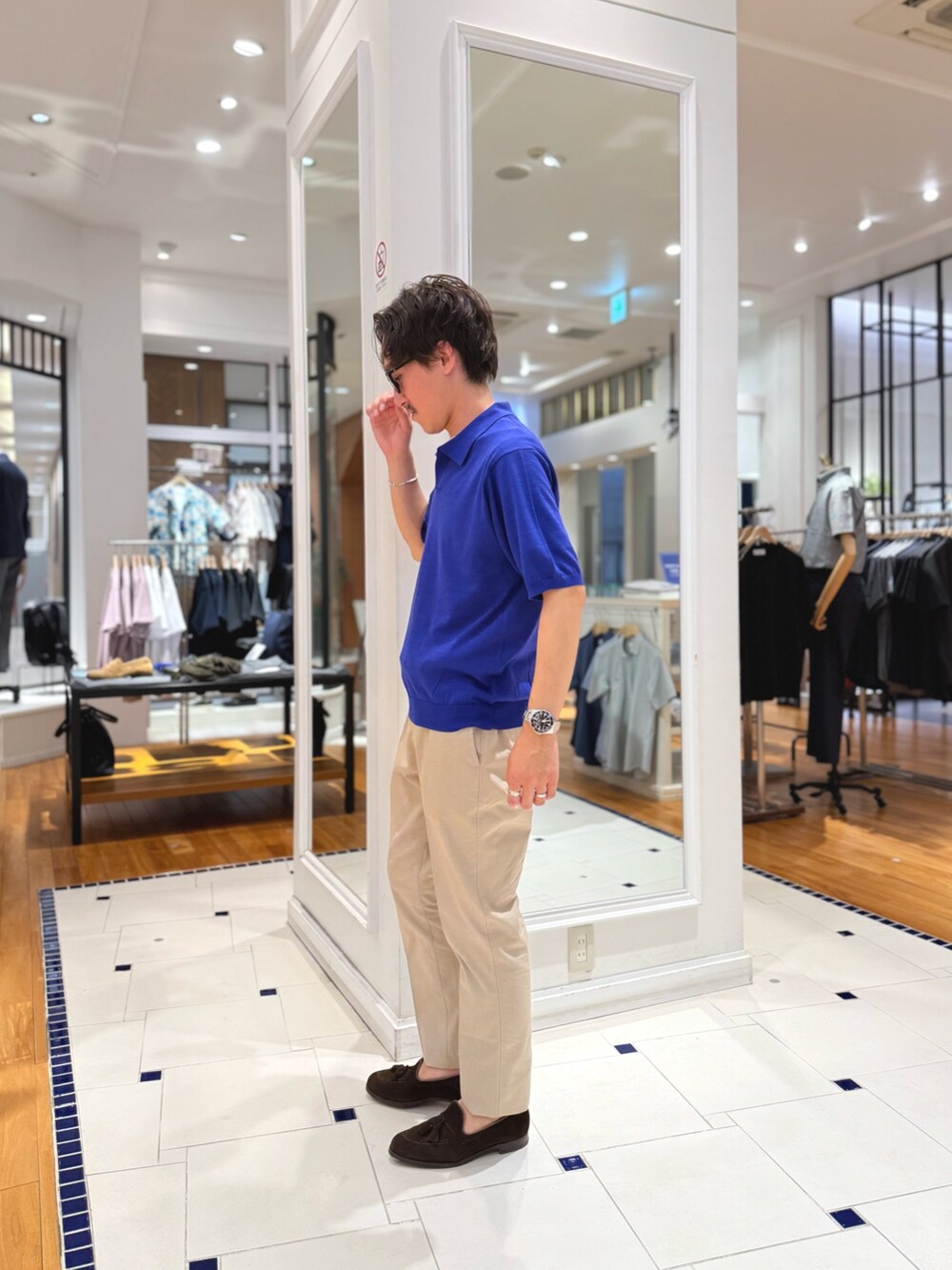 ブルー系のポロシャツ、ベージュ系のその他パンツ、ブラウン系のローファーを着用したメンズの春コーディネートの6枚目の写真