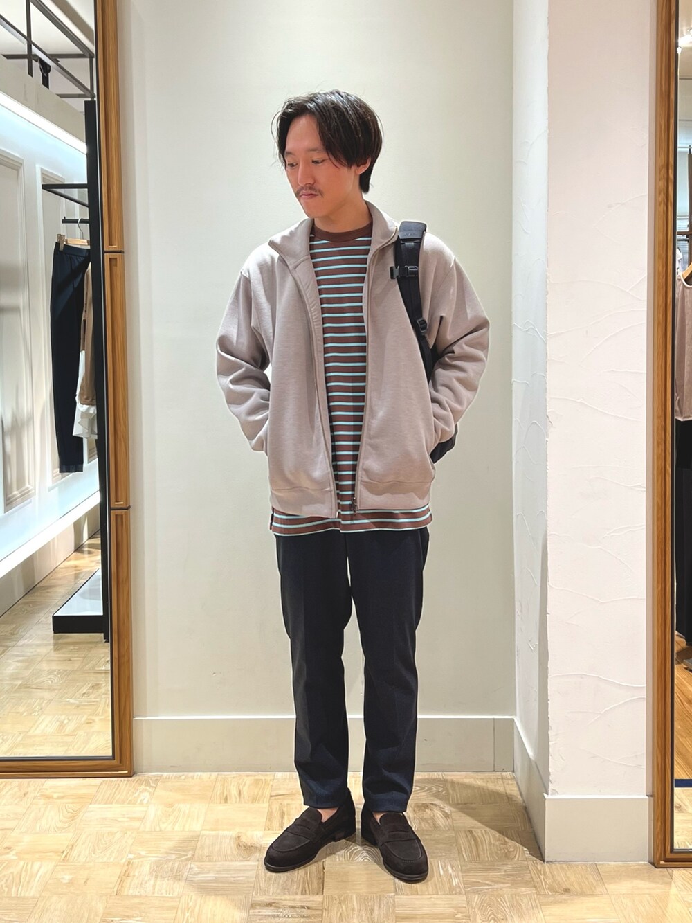 ブラウン系のローファー、ブラック系のバックパック/リュック、ブルー系のその他パンツを着用したメンズの秋コーディネートの2枚目の写真