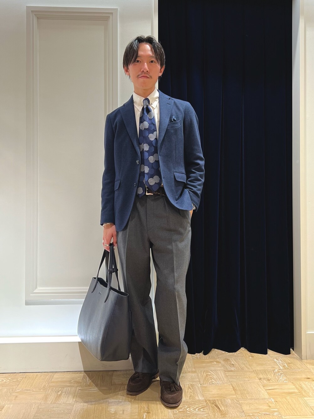 ブルー系のテーラードジャケット、ブルー系のネクタイ、ブルー系のトートバッグを着用したメンズの冬コーディネートの3枚目の写真