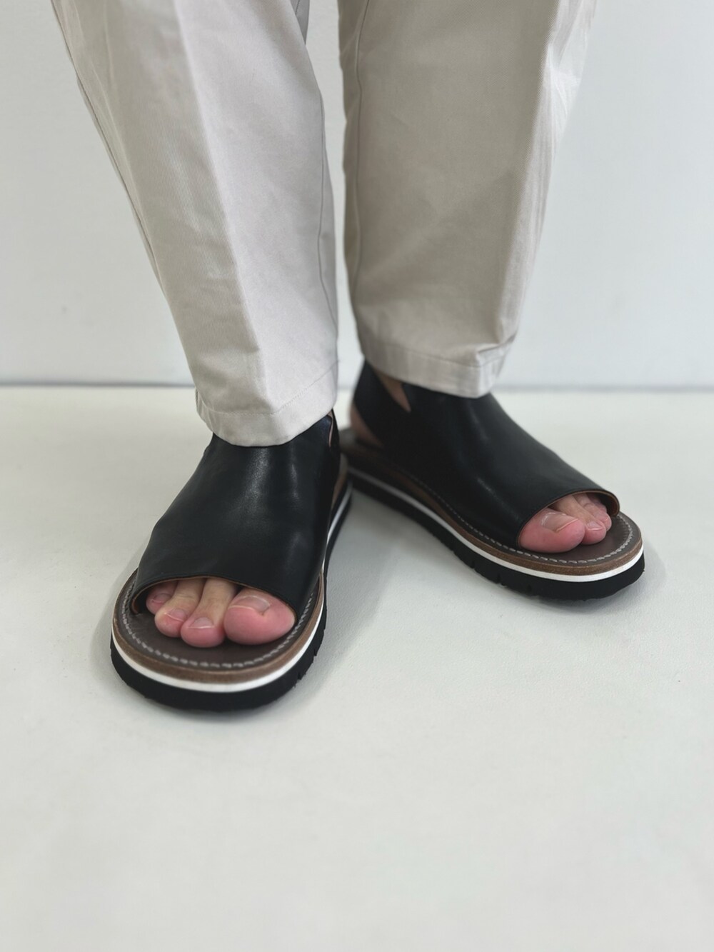 ホワイト系のTシャツ/カットソー、ブラック系のショルダーバッグ、ブラック系のサンダルを着用したメンズの春コーディネートの6枚目の写真