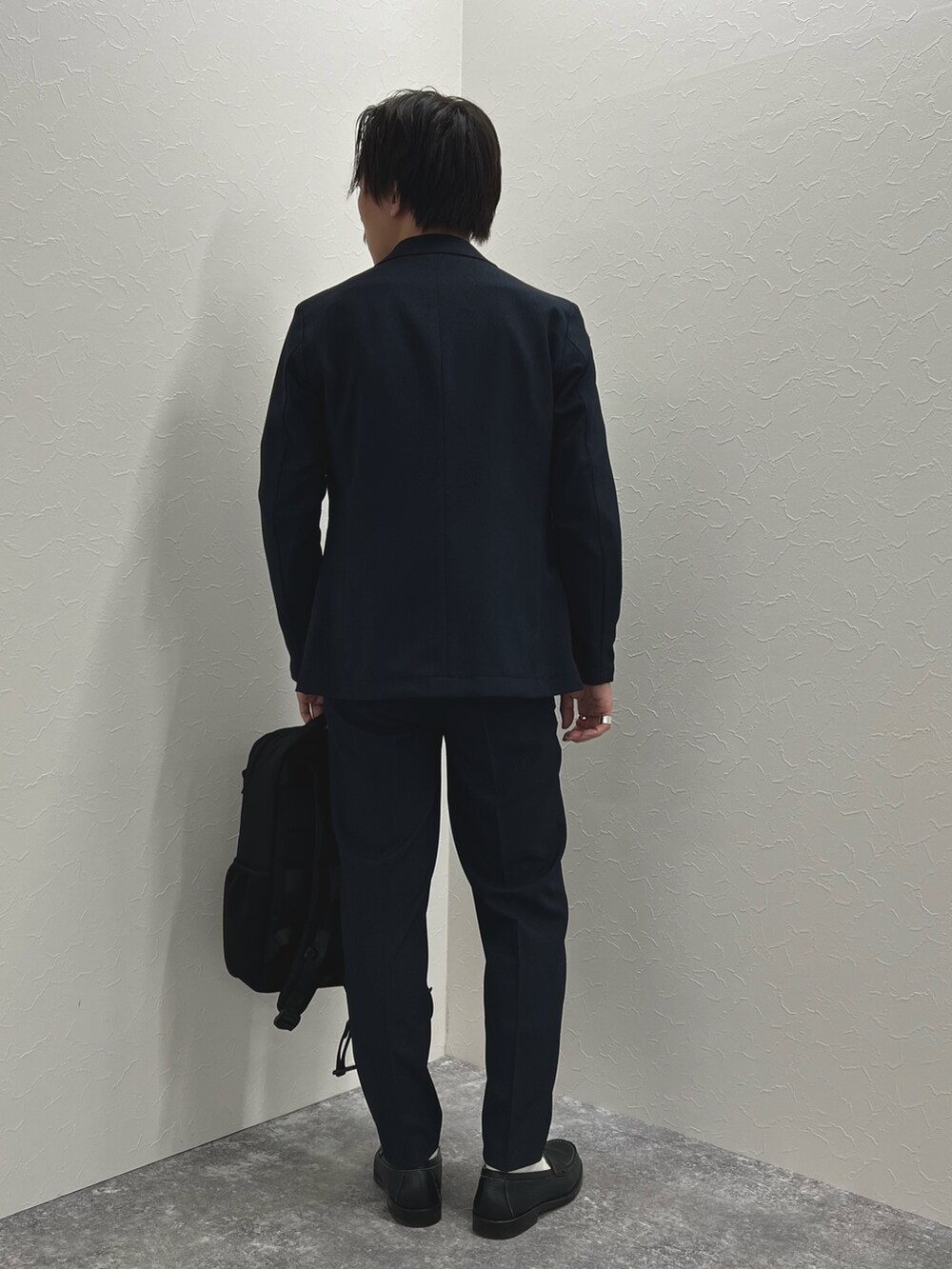 ブルー系のテーラードジャケット、ブルー系のその他パンツ、ブラック系のバックパック/リュックを着用したメンズの秋コーディネートの4枚目の写真