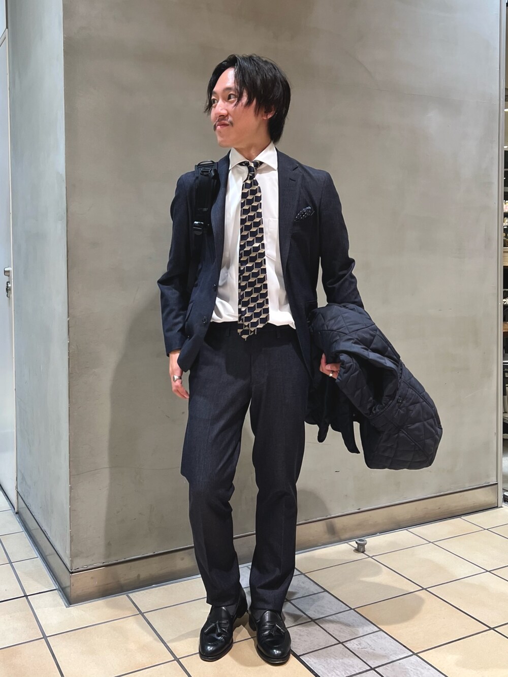 ブルー系のテーラードジャケット、ホワイト系のビジネスシャツ、ブルー系のネクタイを着用したメンズの秋コーディネートの2枚目の写真