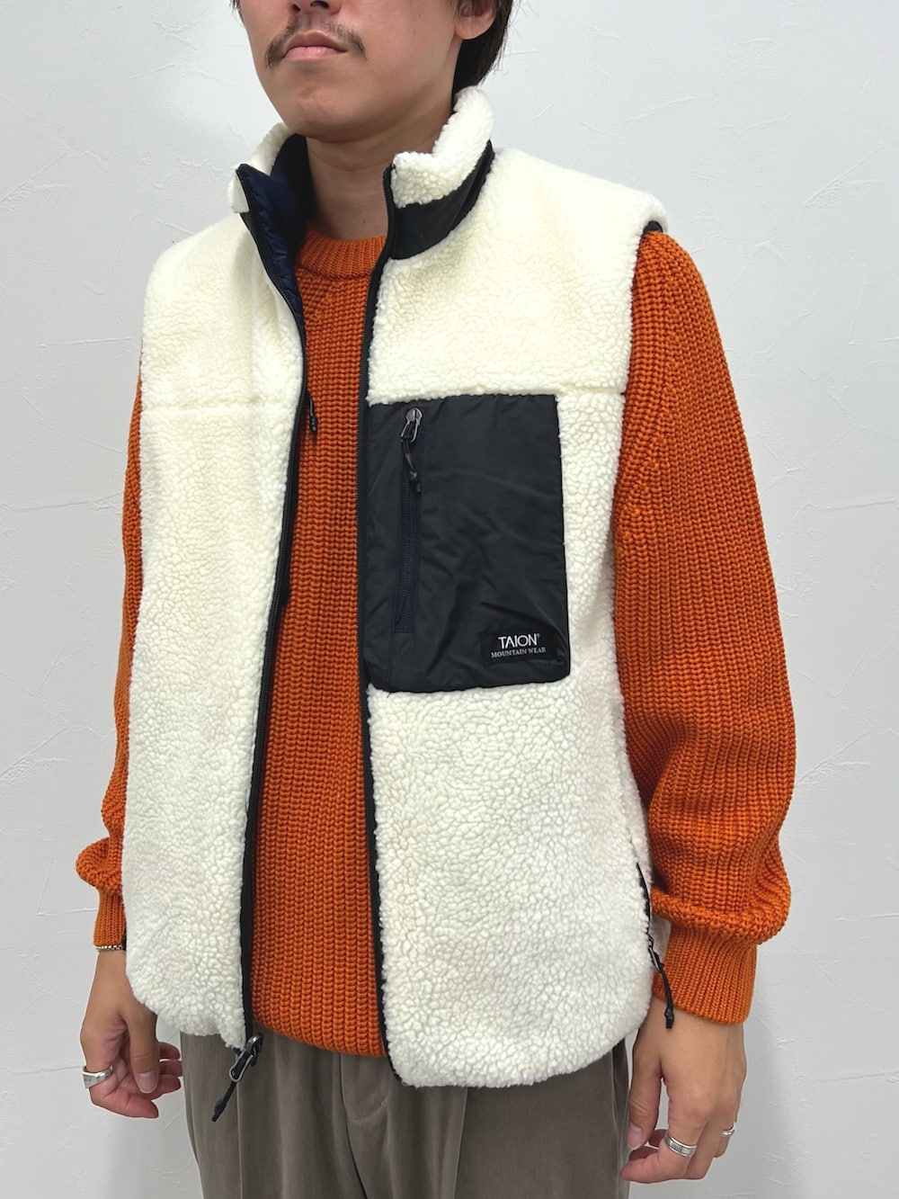 ホワイト系のダウンベスト、ベージュ系のその他パンツを着用したメンズの秋コーディネートの10枚目の写真