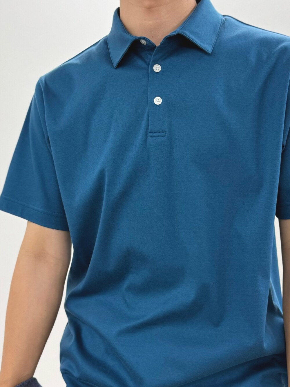 ブルー系のポロシャツ、ベージュ系のチノパンツ、ブルー系のテーラードジャケットを着用したメンズの夏コーディネートの7枚目の写真