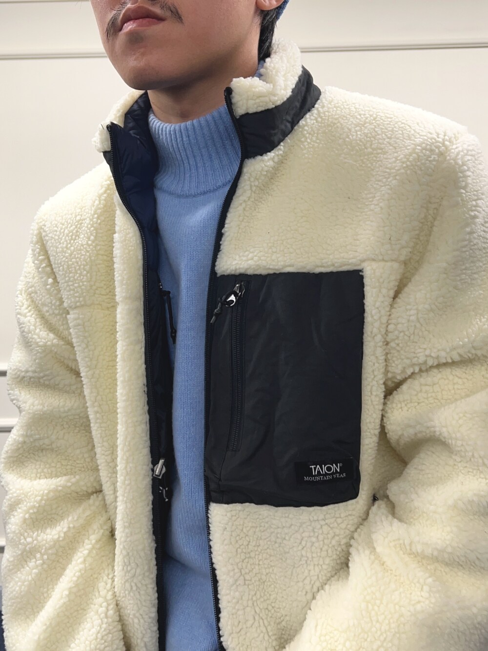 ブルー系のニット/セーター、ホワイト系のブルゾン、ブラック系のバックパック/リュックを着用したメンズの秋コーディネートの7枚目の写真