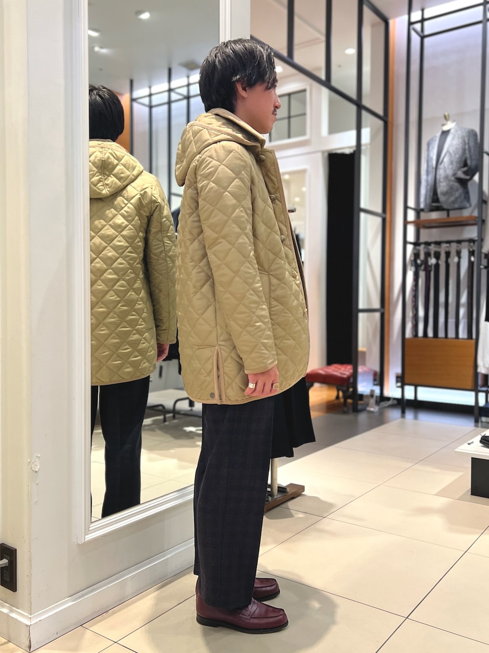 ベージュ系のブルゾン、ブルー系のテーラードジャケット、ブラウン系のローファーを着用したメンズの冬コーディネートの6枚目の写真