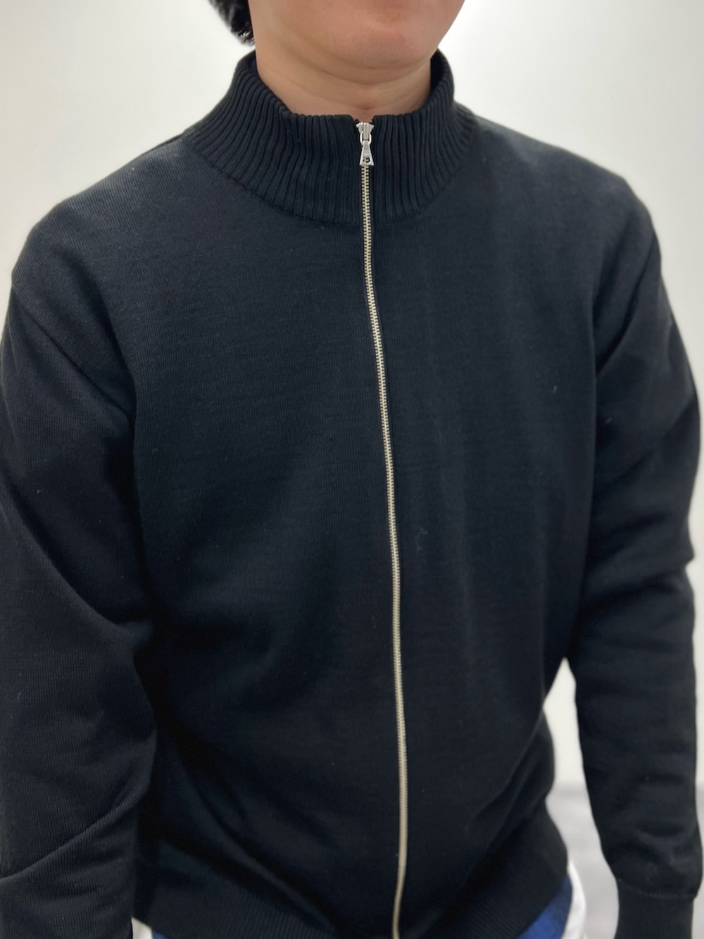 ブラック系のカーディガン/ボレロ、ブルー系のシャツ/ブラウス、ホワイト系のデニムパンツを着用したメンズの冬コーディネートの7枚目の写真