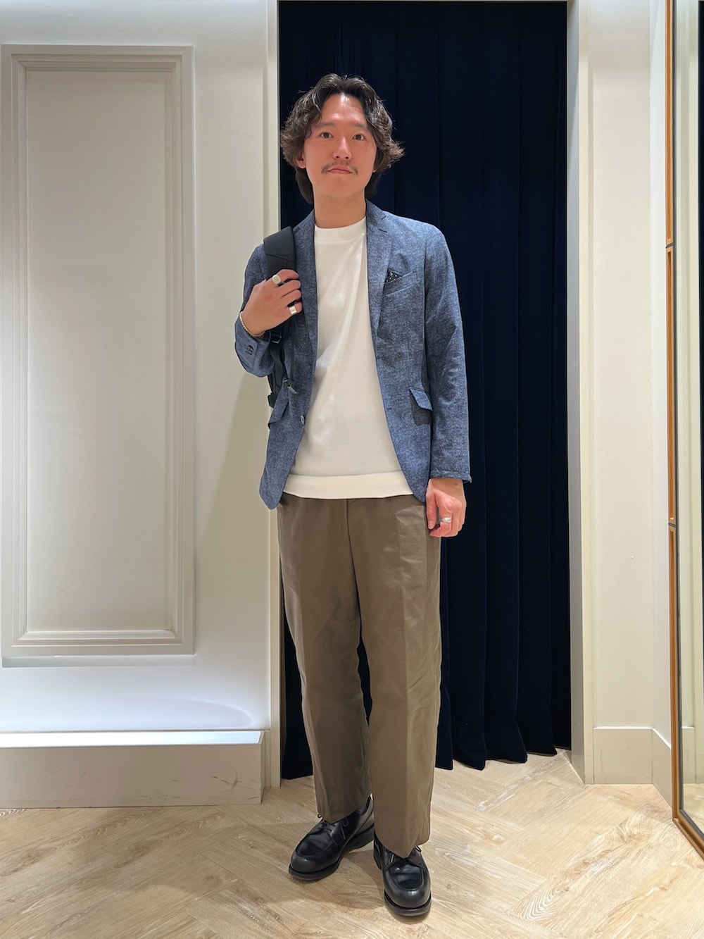 ホワイト系のTシャツ/カットソー、ブラック系のバックパック/リュック、ブラック系のその他シューズを着用したメンズの春コーディネートの3枚目の写真