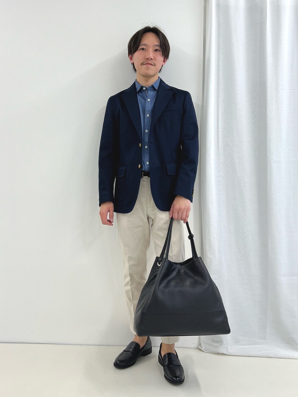 ブルー系のシャツ/ブラウス、ホワイト系のチノパンツ、ブラック系のローファーを着用したメンズの春コーディネートの2枚目の写真