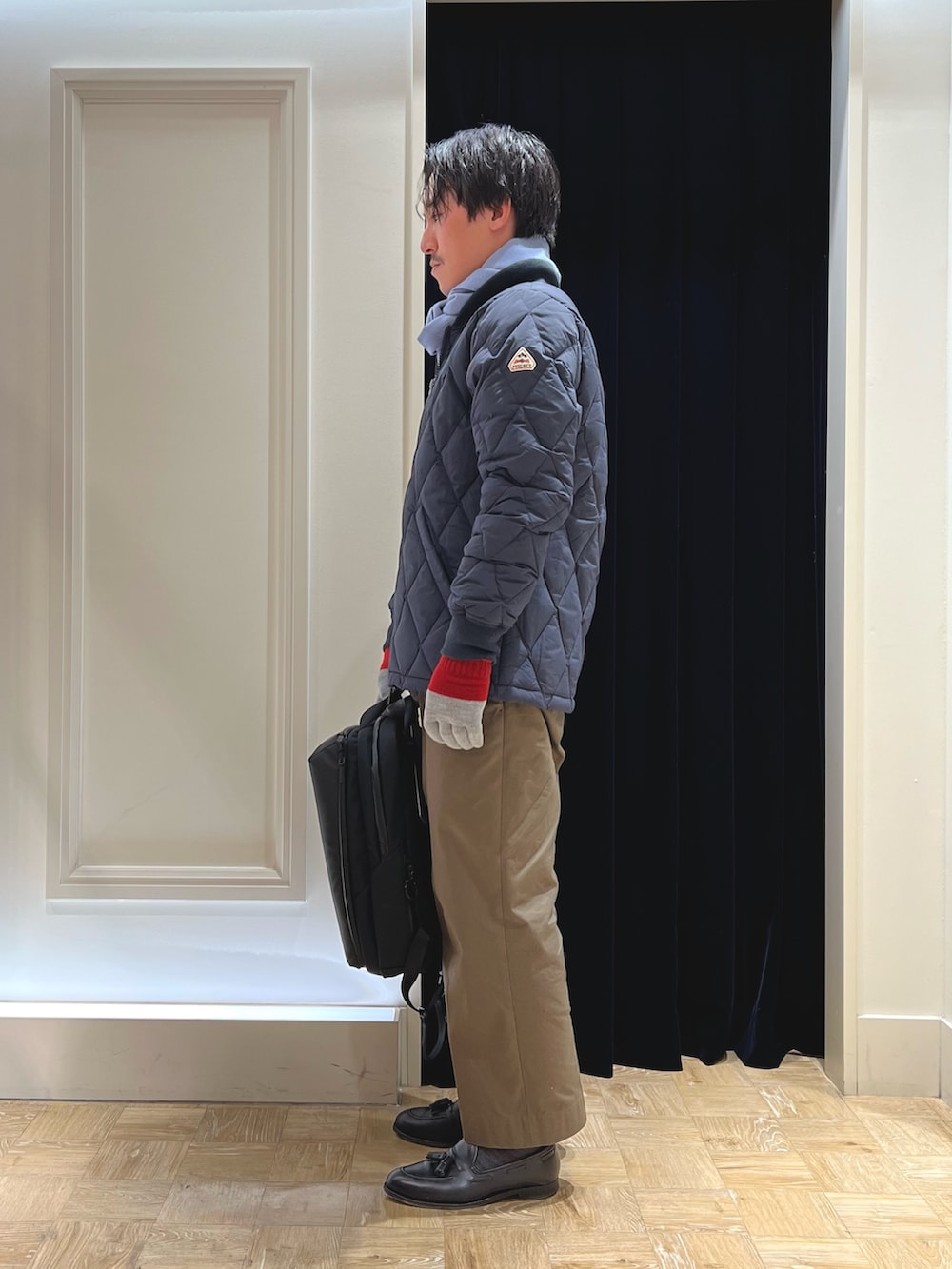 ブルー系のダウンジャケット/コート、ブラック系のバックパック/リュック、ブルー系のマフラーを着用したメンズの冬コーディネートの4枚目の写真