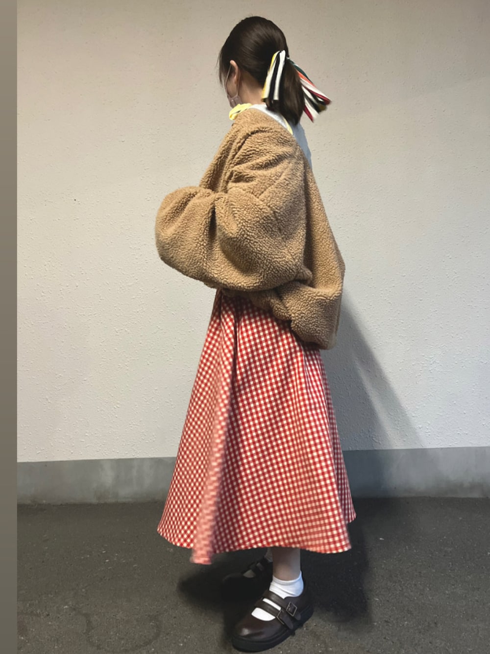 ベージュ系のブルゾン、レッド系のスカート、イエロー系のトップスを着用したレディースの秋コーディネートの2枚目の写真