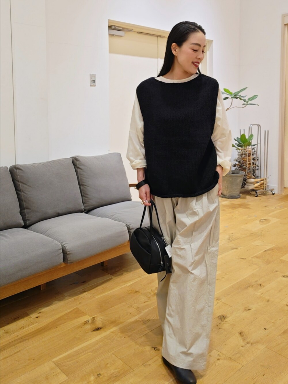 ブラック系のベストを着用したレディースの秋コーディネートの2枚目の写真