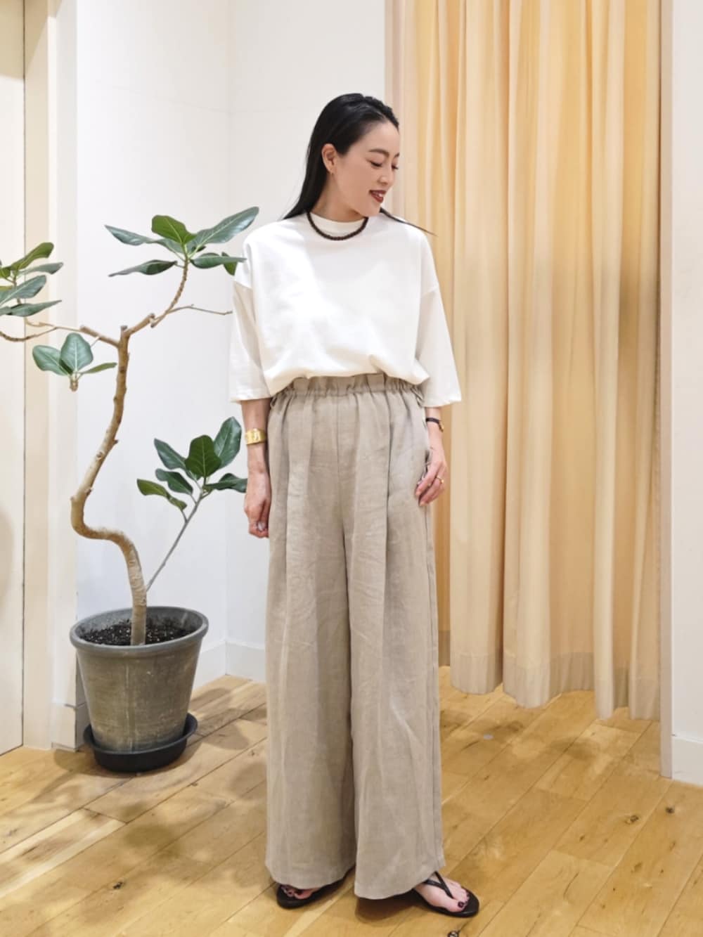 ベージュ系のパンツ、ホワイト系のトップスを着用したレディースの春コーディネートの2枚目の写真