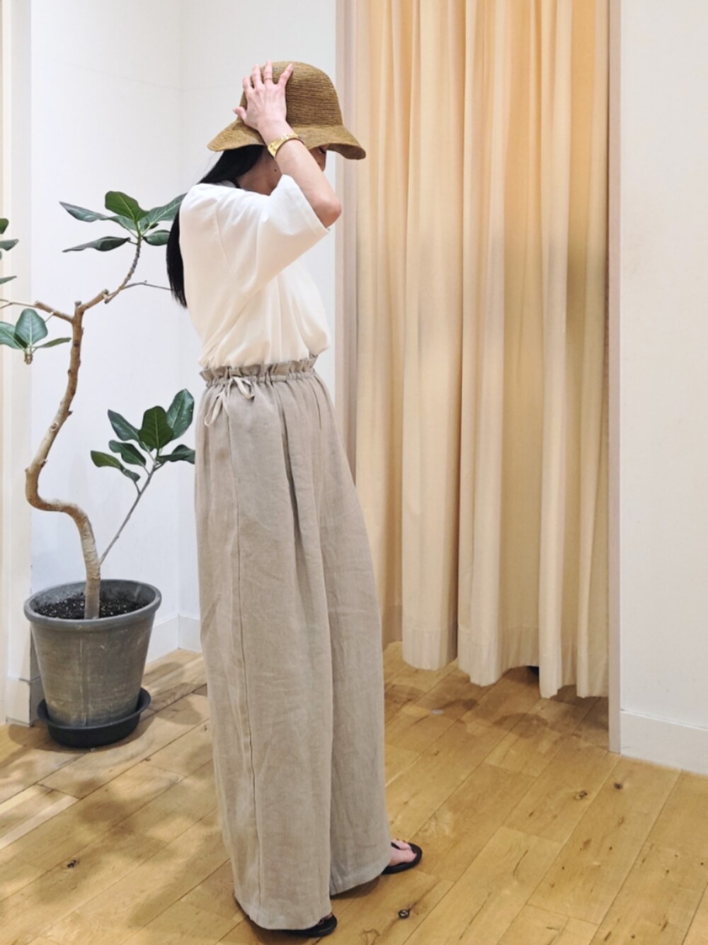 ベージュ系のパンツ、ホワイト系のトップスを着用したレディースの春コーディネートの3枚目の写真
