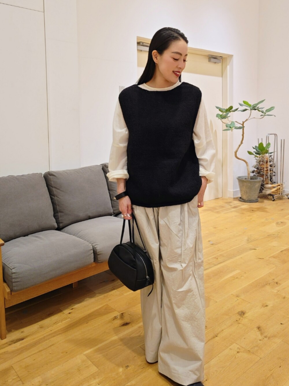 ブラック系のベストを着用したレディースの秋コーディネートの3枚目の写真