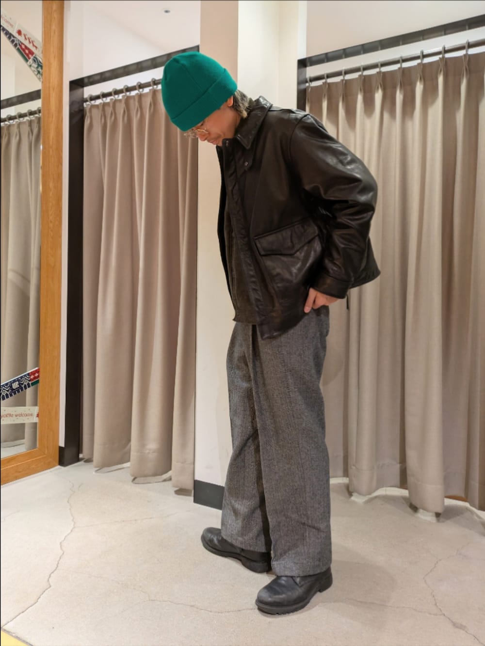 ブラック系のその他アウター、グリーン系のカーディガン/ボレロ、グレー系のその他パンツを着用したメンズの冬コーディネートの4枚目の写真