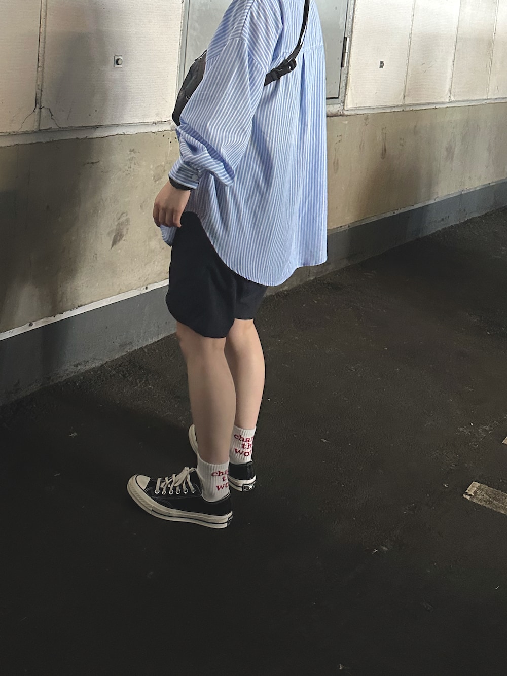 ブラック系のスニーカー、ブラック系のショルダーバッグ、ブラック系のパンツを着用したレディースの秋コーディネートの2枚目の写真