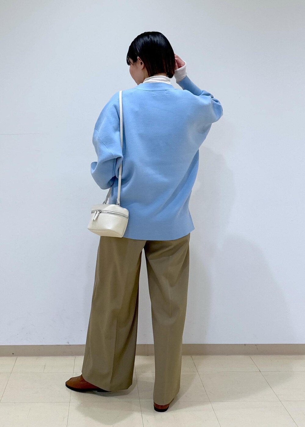 ブラウン系のローファー、ブルー系のカーディガン/ボレロ、ホワイト系のニット/セーターを着用したレディースの冬コーディネートの4枚目の写真