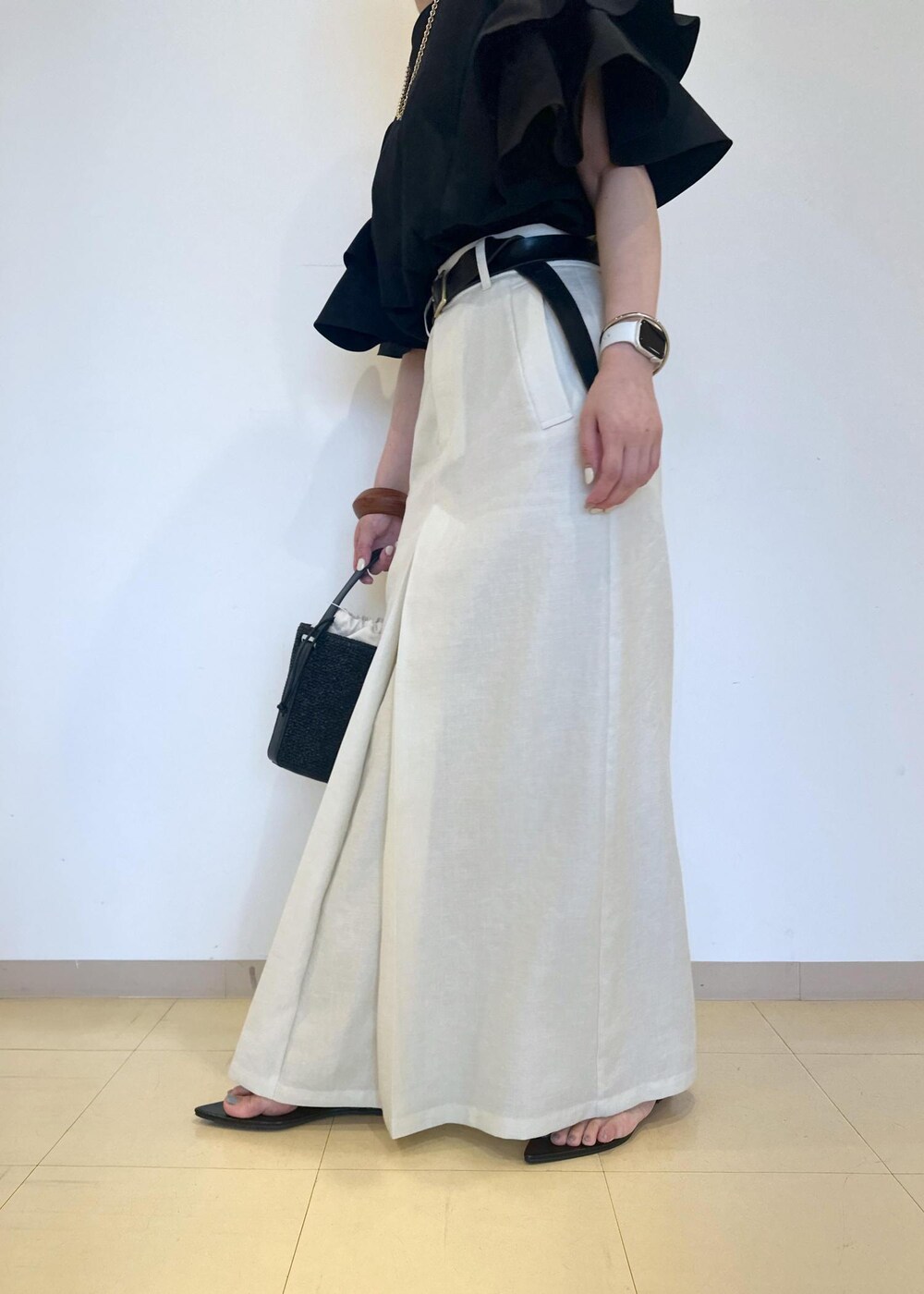 ホワイト系のスカート、ブラック系のサンダル、ブラック系のTシャツ/カットソーを着用したレディースの夏コーディネートの8枚目の写真
