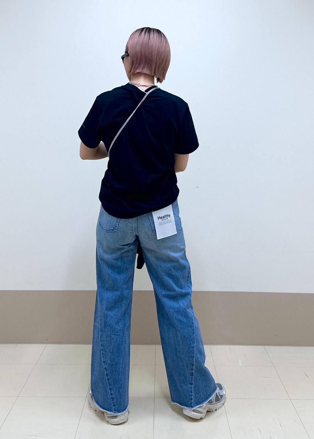 ブルー系のデニムパンツ、ブラック系のテーラードジャケット、ブラック系のハンドバッグを着用したレディースの春コーディネートの6枚目の写真